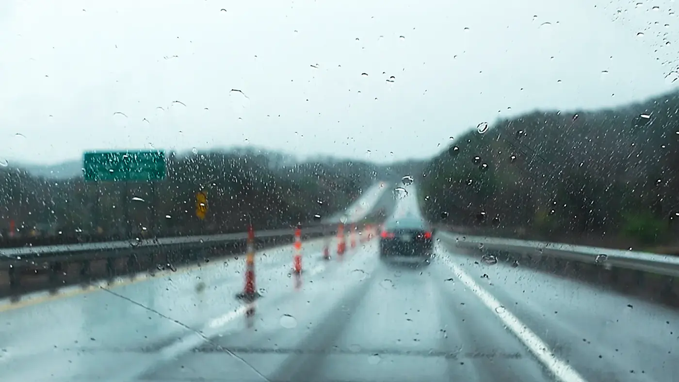 Construction cones on a wet mountain road