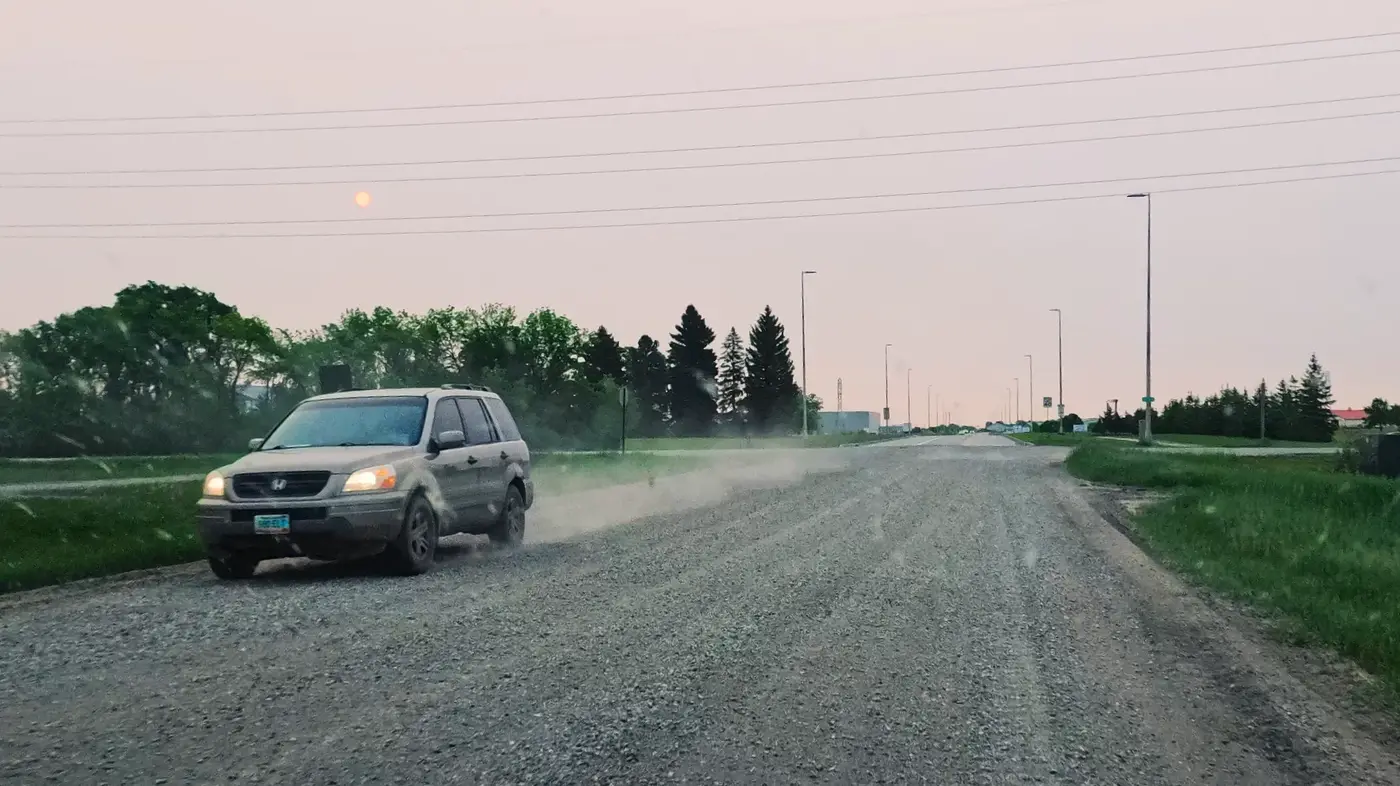 Dusty gravel road through farmland