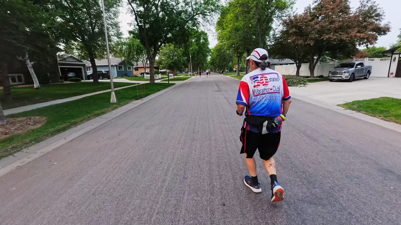 Runner ahead on a brick-paved street