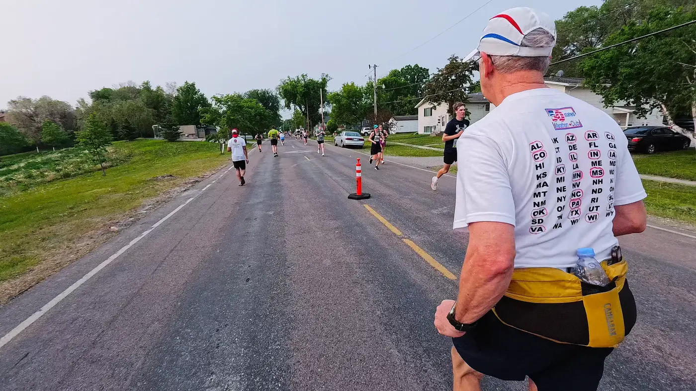 Runner with mile markers behind him