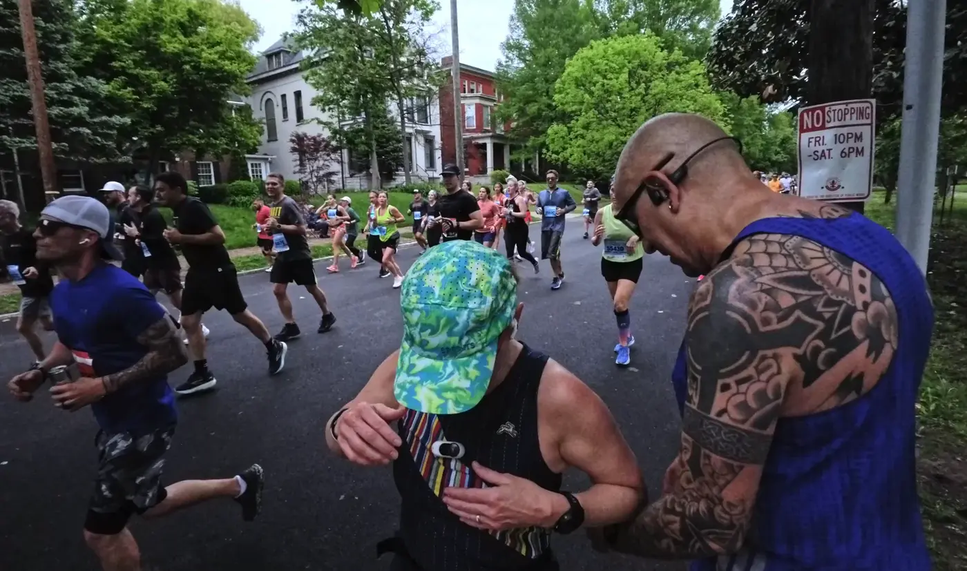 Tattooed spectator greeting runners