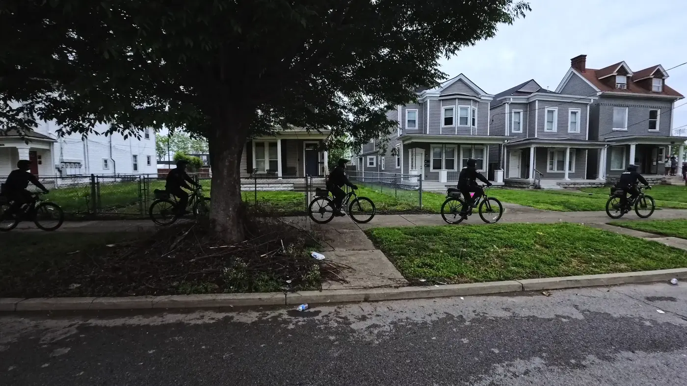 Cyclists and big houses beside the course