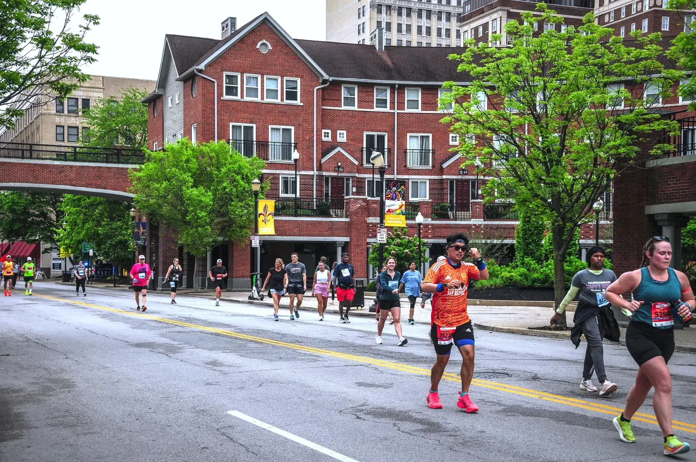 Orange shirt in front of red-brick buildings