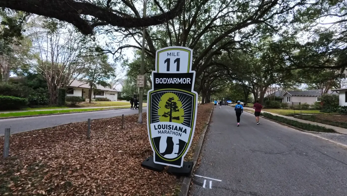 Mile 11 sign on a leaf-covered street