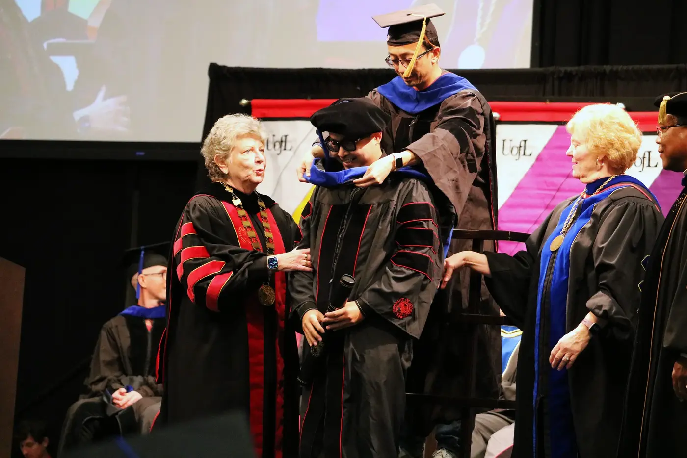 Hooding and handshake on stage