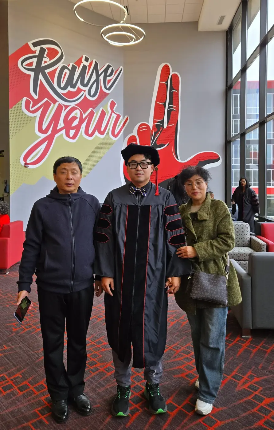 Graduation photo in front of Raise You L