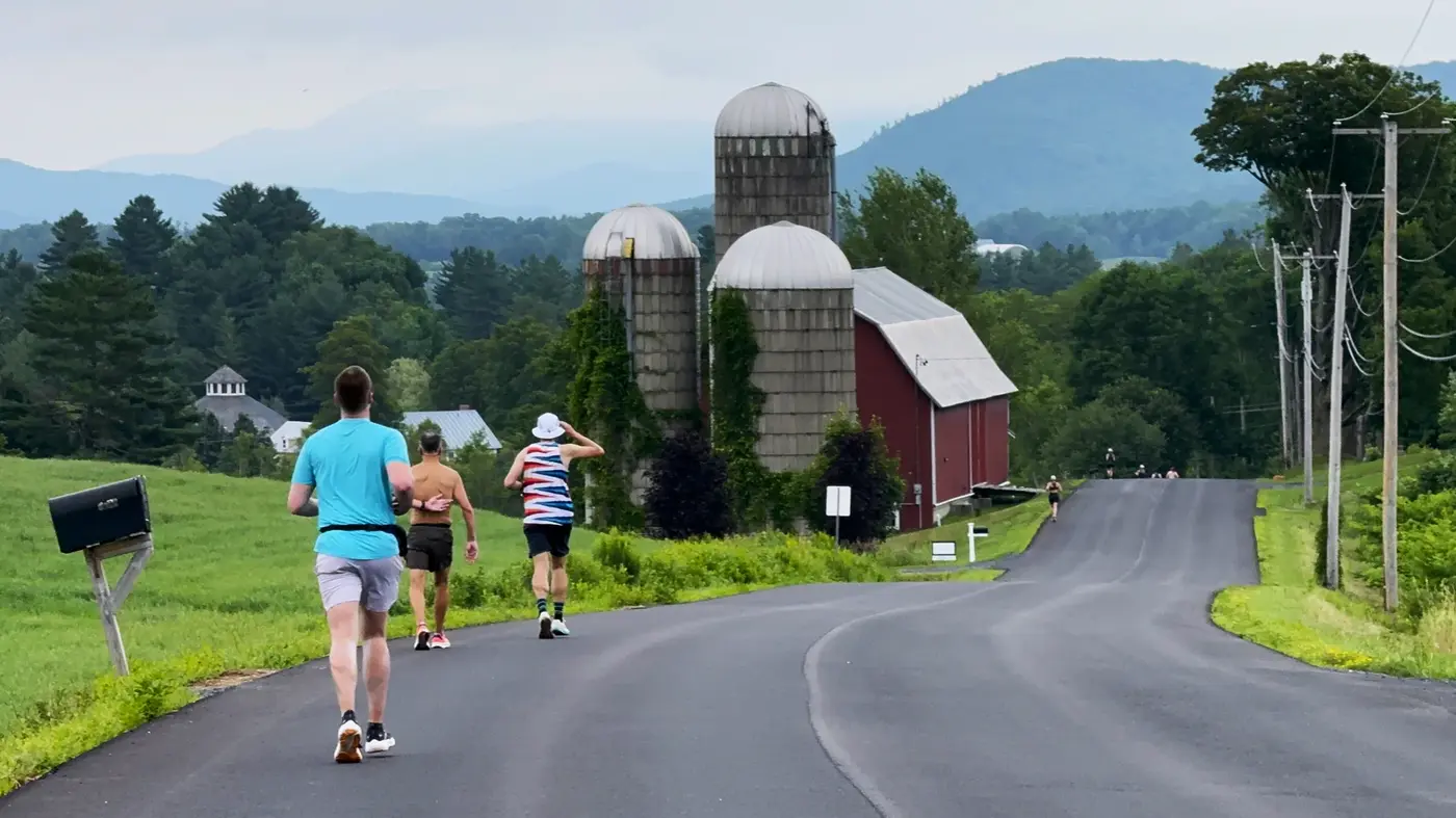 Red barn and silos on a downhill curve