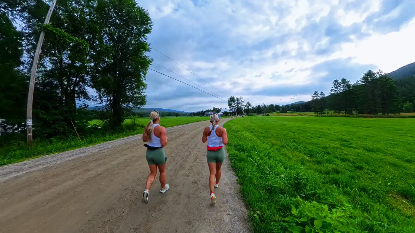 Runners passing an open green field