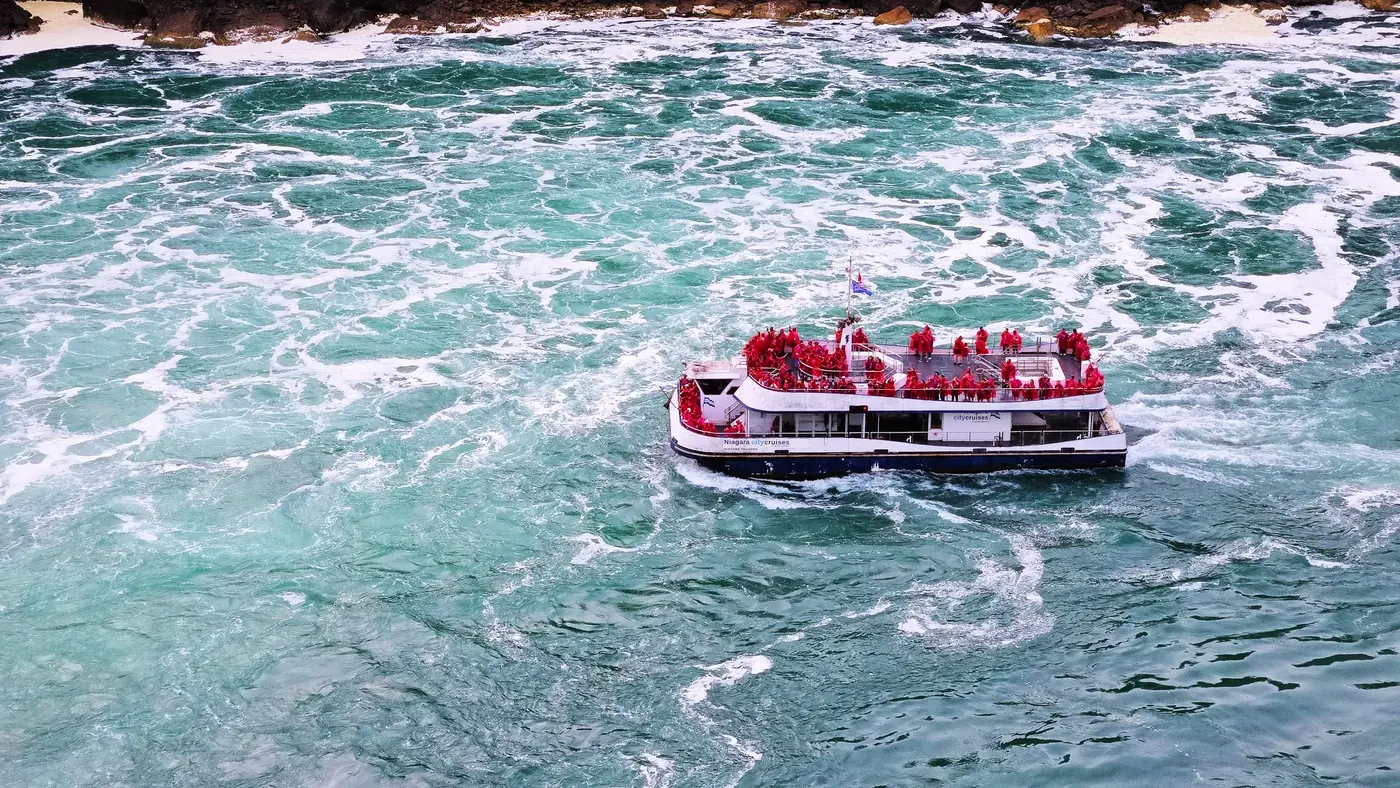 Tour boat cutting across the green water